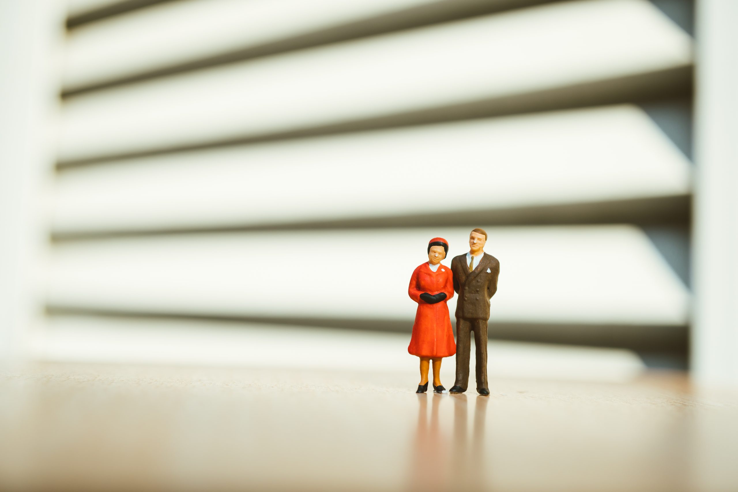 Miniature people, man and woman standing action on green nature